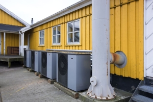 De fire luft-til-vand varmepumper fra danske VÃ¸lund Varmeteknik er anbragt i et hjÃ¸rne bag en bygning. LÃ¸sningen er en gevinst for miljÃ¸et og for KalÃ¸vig BÃ¥delaug, som sparer ca. 145.000 kr. om Ã¥ret.